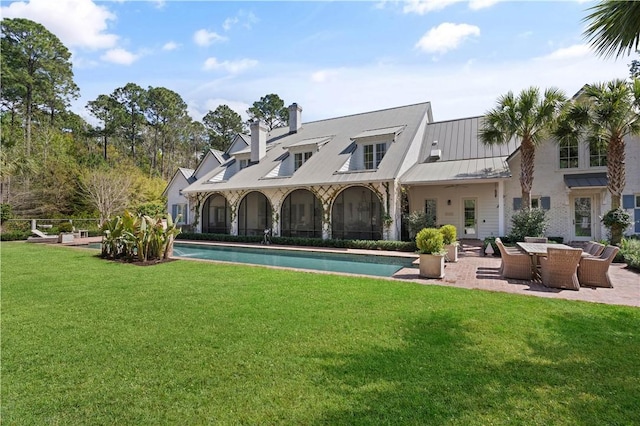 rear view of property featuring outdoor lounge area, a yard, and a patio