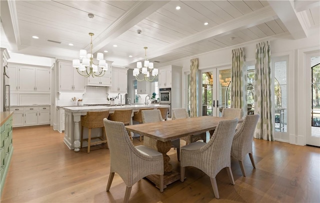 dining space featuring beam ceiling, light wood-type flooring, and a wealth of natural light