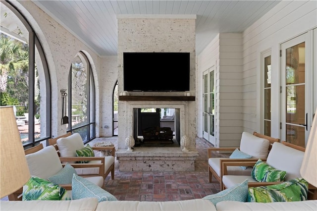 living room with a large fireplace, wooden ceiling, and a wealth of natural light