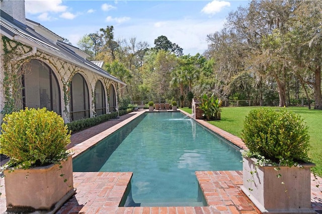 view of swimming pool with a lawn and pool water feature