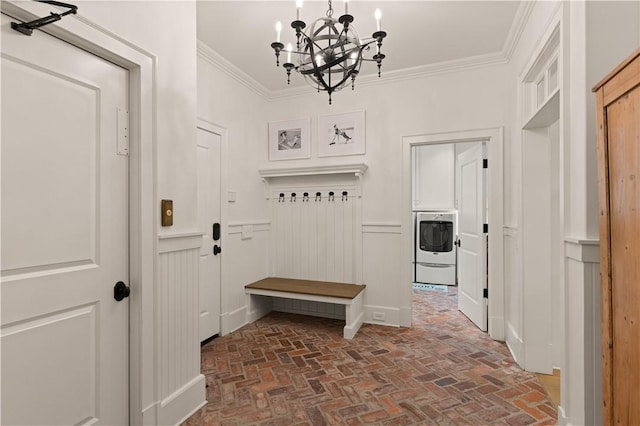 mudroom with washer / dryer, an inviting chandelier, and crown molding