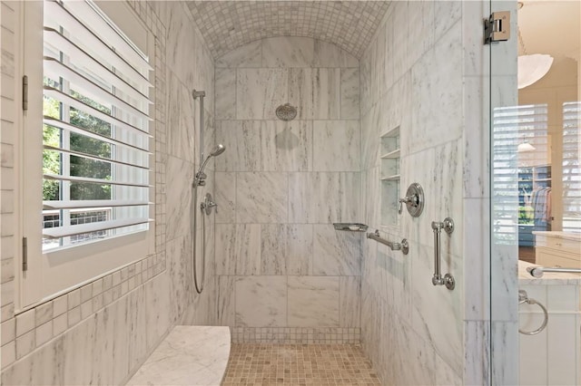 bathroom with a tile shower and tile walls