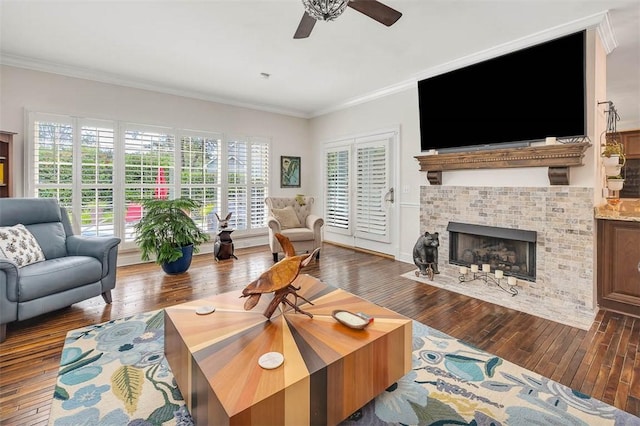 living room with ceiling fan, a fireplace, dark hardwood / wood-style floors, and ornamental molding