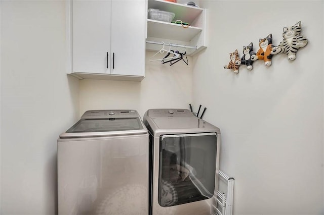 laundry room featuring washing machine and dryer and cabinets