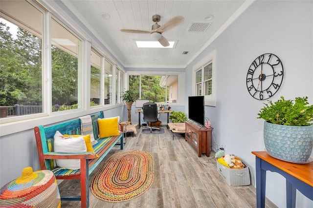 sunroom with ceiling fan, a healthy amount of sunlight, and wooden ceiling