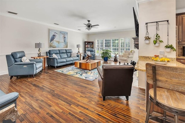 living room with crown molding, ceiling fan, and dark hardwood / wood-style floors