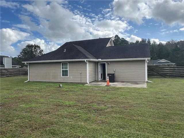 rear view of house with a patio, cooling unit, and a lawn