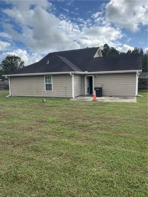 back of property featuring a lawn, central air condition unit, and a patio area