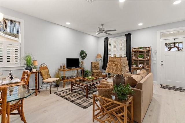 living room featuring light wood-type flooring and ceiling fan