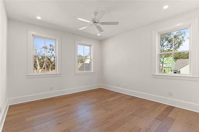 spare room with hardwood / wood-style flooring, ceiling fan, and plenty of natural light