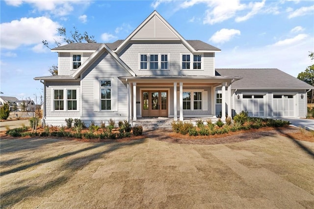 view of front of house featuring a porch, a garage, and a front lawn