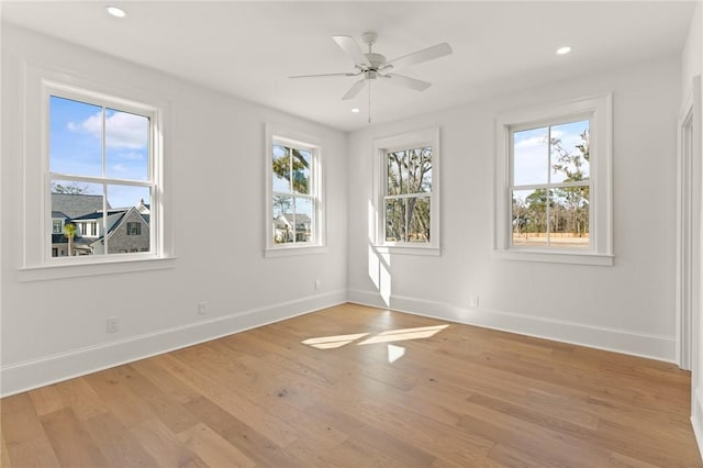 unfurnished room featuring ceiling fan, plenty of natural light, and light wood-type flooring