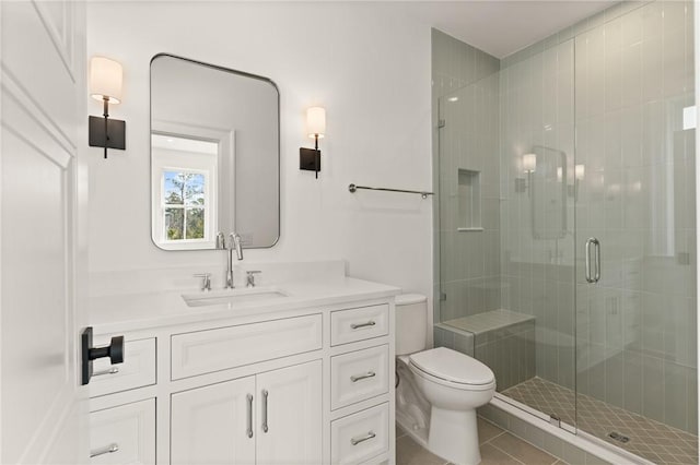 bathroom featuring tile patterned flooring, walk in shower, vanity, and toilet