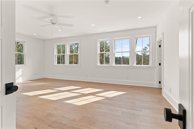 unfurnished room with ceiling fan, light hardwood / wood-style floors, and a healthy amount of sunlight