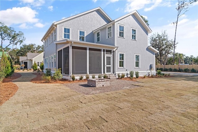 rear view of house with a sunroom and a lawn