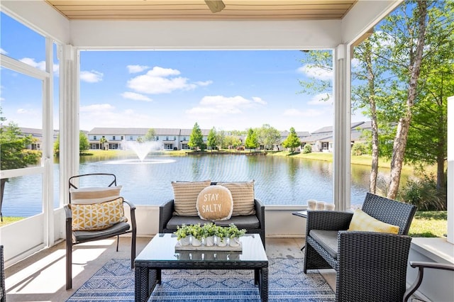sunroom / solarium featuring a water view, a residential view, wood ceiling, and wood finished floors