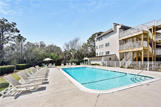 pool with a patio area and fence