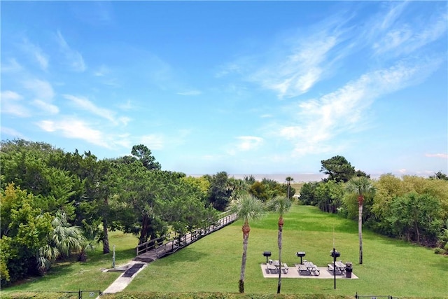 view of community featuring a yard and fence