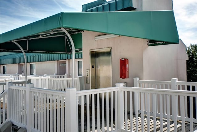 exterior space with elevator and stucco siding