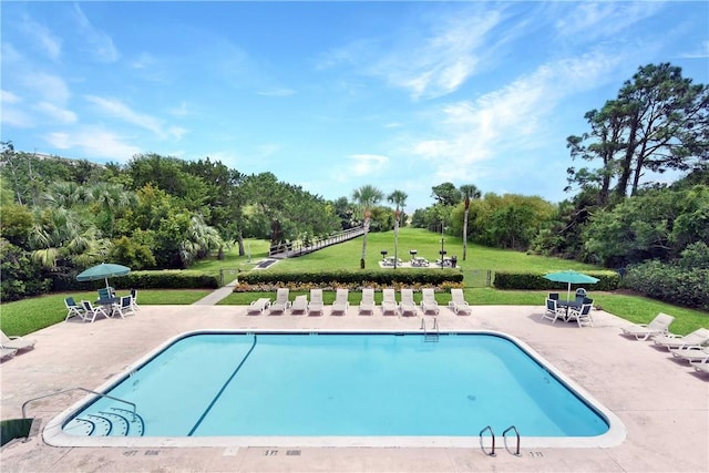 pool featuring a lawn and a patio