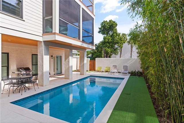 view of pool featuring grilling area and a patio