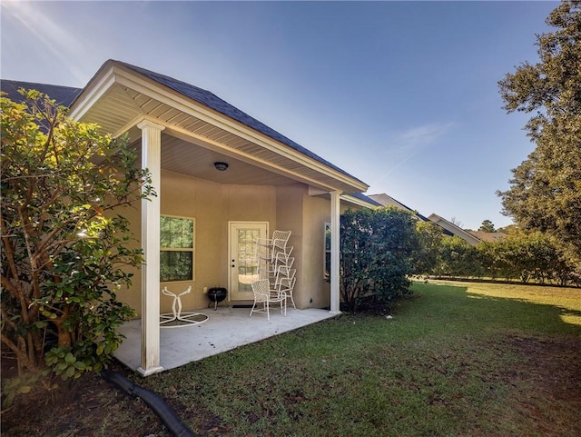 back of property featuring a patio area and a yard