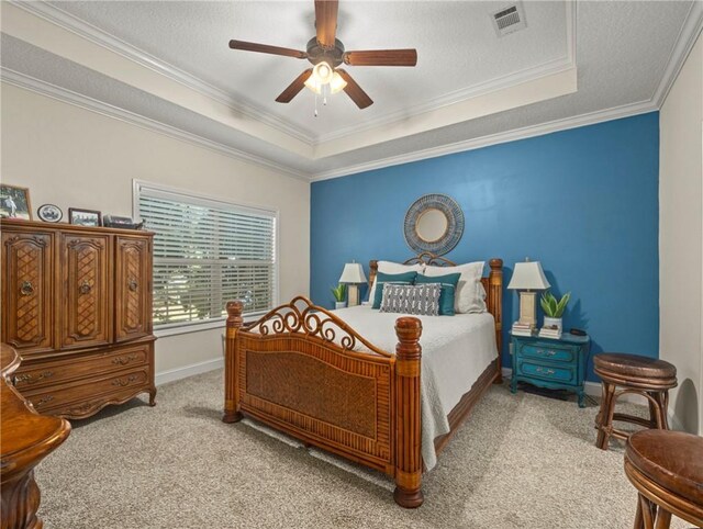 bedroom featuring crown molding, ceiling fan, a textured ceiling, a tray ceiling, and light colored carpet