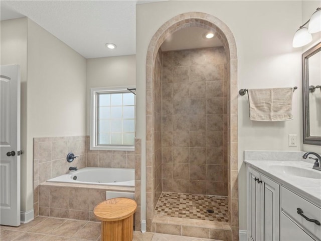 bathroom featuring tile patterned flooring, shower with separate bathtub, and vanity