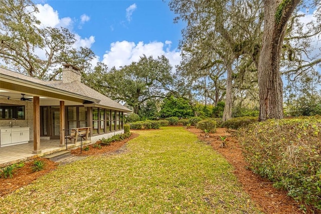 217 Five Pounds Rd, Saint Simons Island, GA 31522 - view of grassy yard with a sink, ceiling fan, a sunroom, and a patio