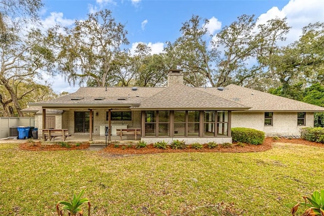 217 Five Pounds Rd, Saint Simons Island, GA 31522 - rear view of house with a yard, a patio area, a chimney, and a shingled roof