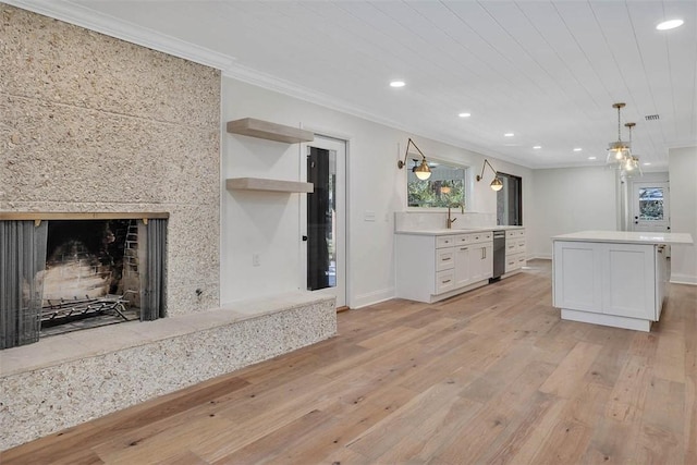 217 Five Pounds Rd, Saint Simons Island, GA 31522 - kitchen featuring light wood-style flooring, recessed lighting, white cabinets, a fireplace, and ornamental molding