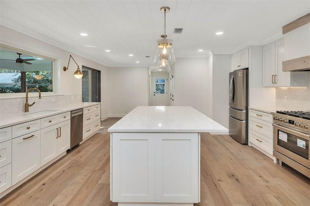 217 Five Pounds Rd, Saint Simons Island, GA 31522 - kitchen featuring stainless steel appliances, a sink, a kitchen island, tasteful backsplash, and white cabinets