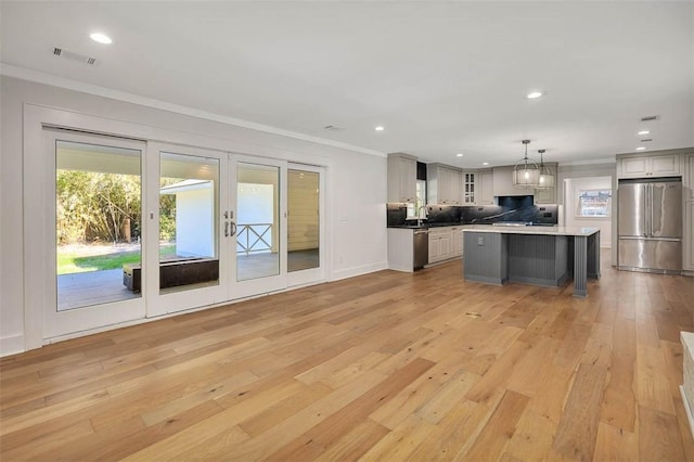 111 Youngwood Dr, Saint Simons Island, GA 31522 - kitchen with stainless steel appliances, crown molding, decorative backsplash, light wood-style flooring, and recessed lighting