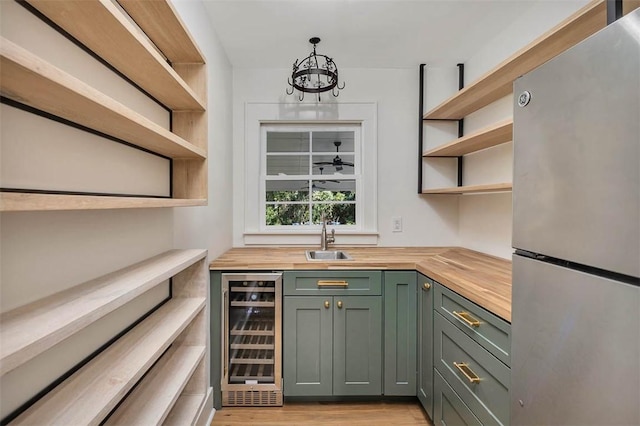 111 Youngwood Dr, Saint Simons Island, GA 31522 - bar area with freestanding refrigerator, beverage cooler, light wood-style flooring, and a chandelier