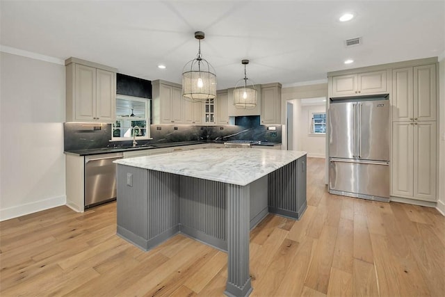 111 Youngwood Dr, Saint Simons Island, GA 31522 - kitchen featuring stainless steel appliances, light wood-style floors, tasteful backsplash, recessed lighting, and crown molding