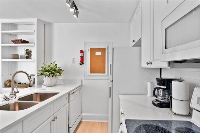 kitchen featuring white cabinets, white appliances, light hardwood / wood-style floors, and sink