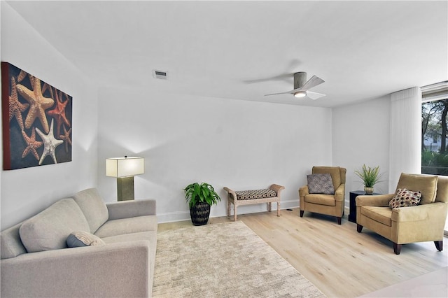 living room with ceiling fan and light hardwood / wood-style flooring