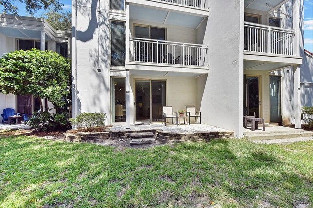 rear view of house with a lawn and a patio