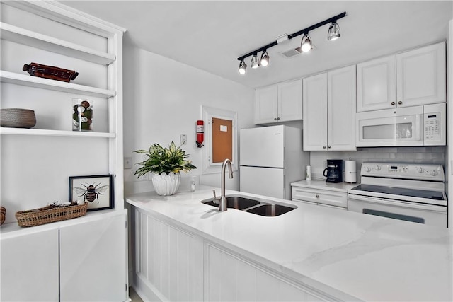 kitchen featuring decorative backsplash, light stone countertops, white appliances, sink, and white cabinets