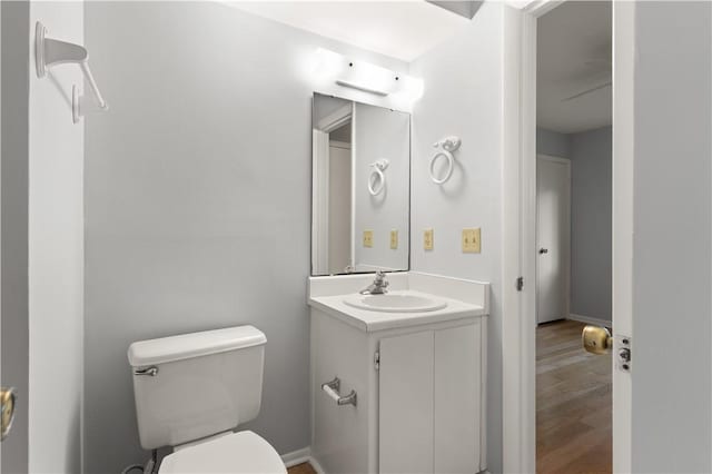 bathroom with wood-type flooring, vanity, and toilet