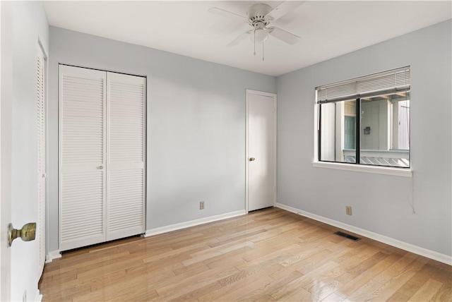 unfurnished bedroom featuring ceiling fan, light wood-type flooring, and a closet