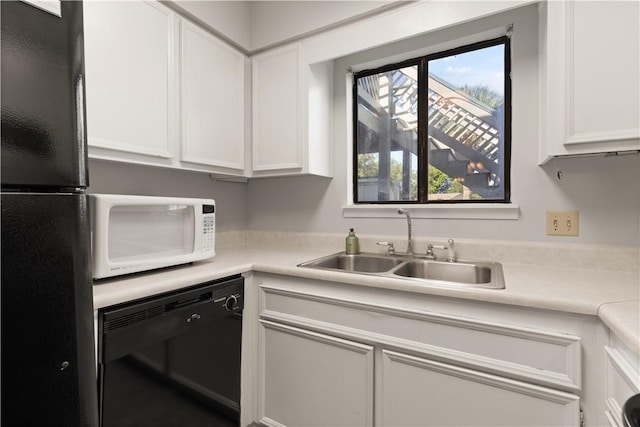 kitchen with sink, white cabinets, and black appliances