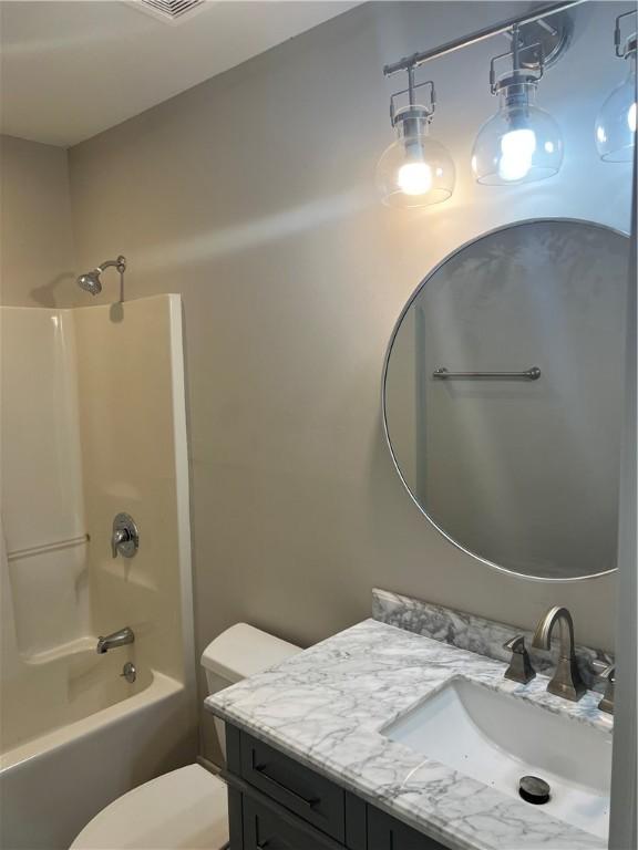 bathroom featuring shower / bathing tub combination, vanity, and toilet