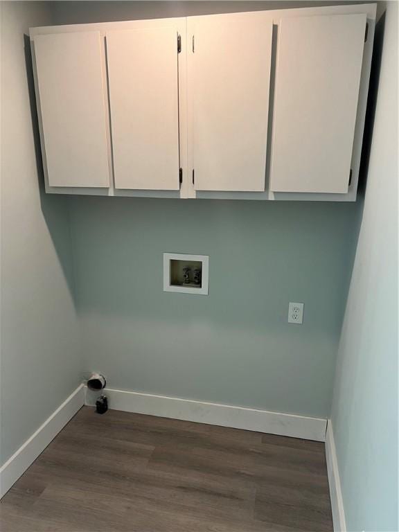 washroom with cabinet space, baseboards, washer hookup, and dark wood-type flooring