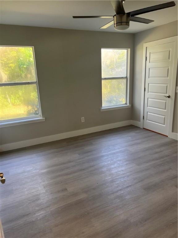 unfurnished room with ceiling fan, baseboards, and wood finished floors