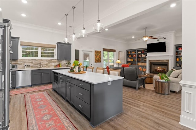 98 Bartram Trl, Brunswick, GA 31523 - kitchen featuring stainless steel appliances, crown molding, light countertops, a ceiling fan, and a kitchen island