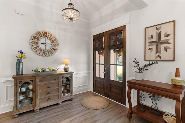98 Bartram Trl, Brunswick, GA 31523 - foyer entrance with french doors, wood finished floors, a chandelier, a decorative wall, and wainscoting