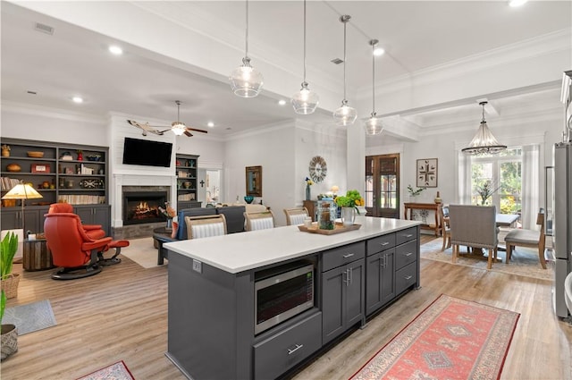 98 Bartram Trl, Brunswick, GA 31523 - kitchen featuring appliances with stainless steel finishes, ceiling fan, a high end fireplace, a center island, and light countertops