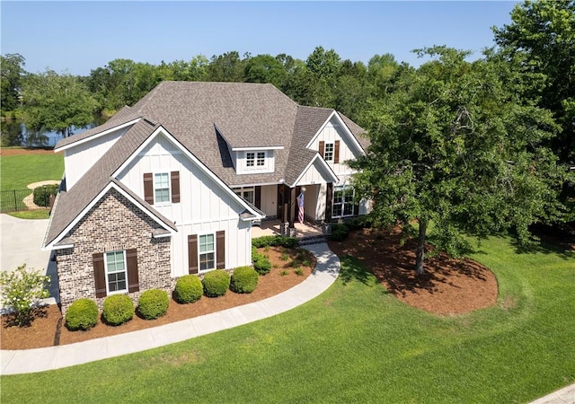 98 Bartram Trl, Brunswick, GA 31523 - view of front of home with board and batten siding, roof with shingles, and a front yard
