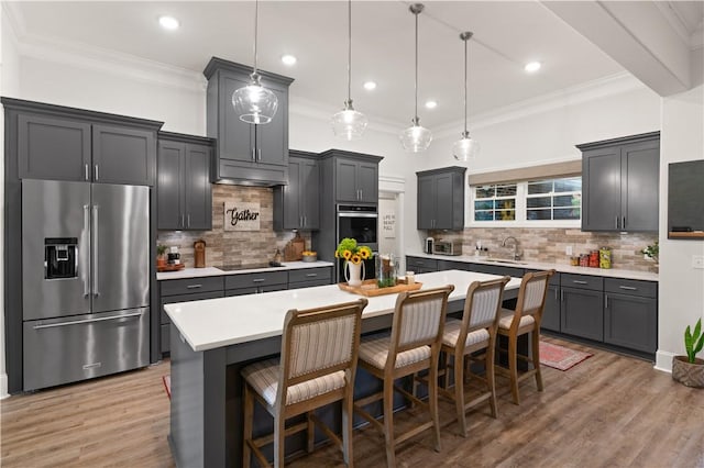 98 Bartram Trl, Brunswick, GA 31523 - kitchen with appliances with stainless steel finishes, a sink, light countertops, a breakfast bar area, and light wood-style floors